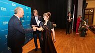 Martin Oberle (links) und Michael Thiem überreichen der   prüfungsbesten Elektronikerin, Svenja Jena, ihr Zeugnis.