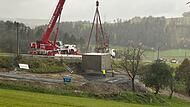 Vor kurzem wurde der Fertigteil-Hochbehälter bei Roßlach in Steilhanglage von einem Schwerlastkran in Filigranarbeit auf den Zentimeter genau am Boden installiert. Nun wartet man auf die Elektroinstallation für die Inbetriebnahme.