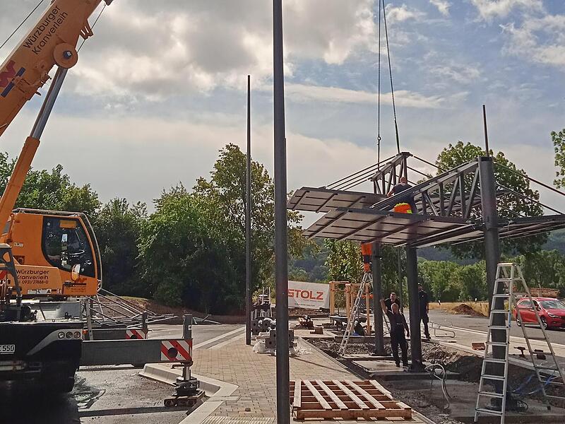 Mit einem Kran wurden die Einzelteile des Buswartehäuschens unterhalb des Feuerwehrhauses montiert. Mit einem Kran wurden die Einzelteile des Buswartehäuschens unterhalb des Feuerwehrhauses montiert.