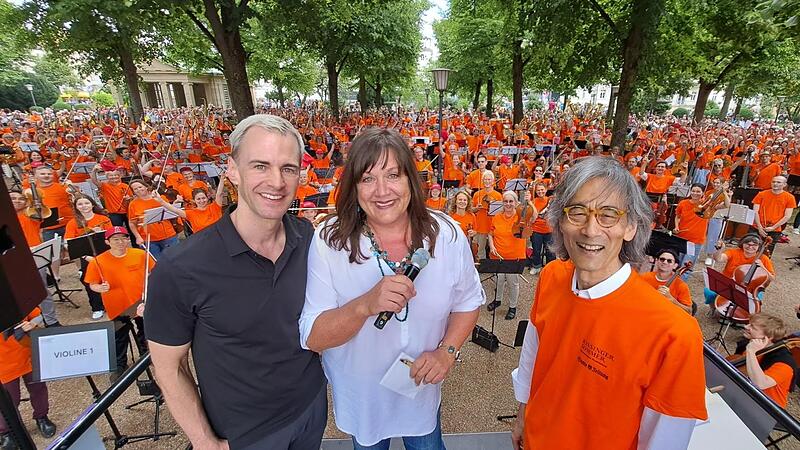 Alexander Steinbeis, Intendant des Kissinger Sommers, Susanne Will, Chefin der Saale-Zeitung, und Stardirigent Kent Nagano. Im Hintergrund das Wichtigste: Die rund 600 Musikerinnen und Musiker, die des zweiten Symphonic Mob zu einem Erlebnis macht...