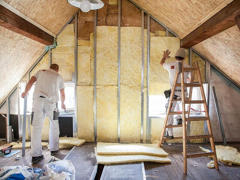 Zwei Handwerker d&auml;mmen ein Dachgeschoss