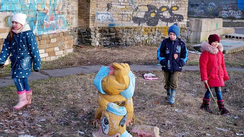 Kinder spielen wenige Tage vor der Invasion am Stadtrand von Awdijwka auf einem aufgelassenen Spielplatz. 500 Meter entfernt liegt ein Minenfeld.