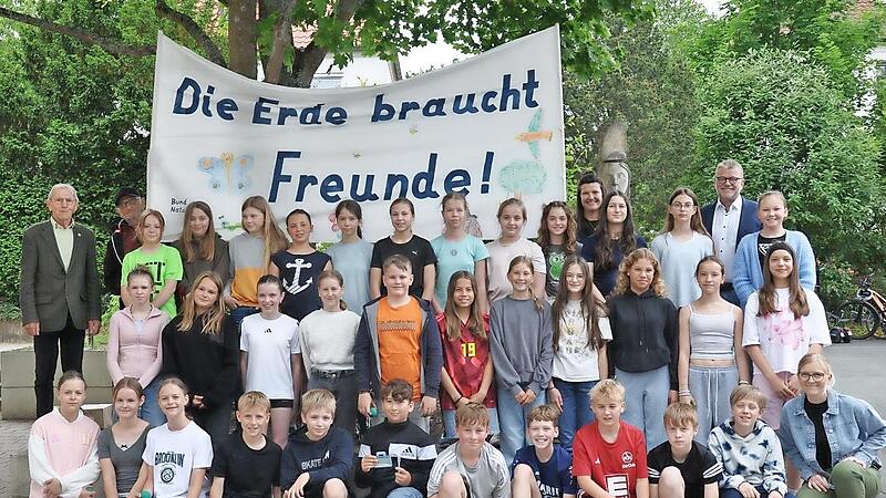 Sch&uuml;ler des MGL setzen sich f&uuml;r den Klimaschutz ein. Unterst&uuml;tzt von den Lehrerinnen Mandy P&uuml;lz (re. neben dem Banner) und Corinna Bogdahn (r. vorne). Begleitet von Schulleiter Tom Carl (re. hinten) und angesto&szlig;en von Anton Reinhardt (l.).