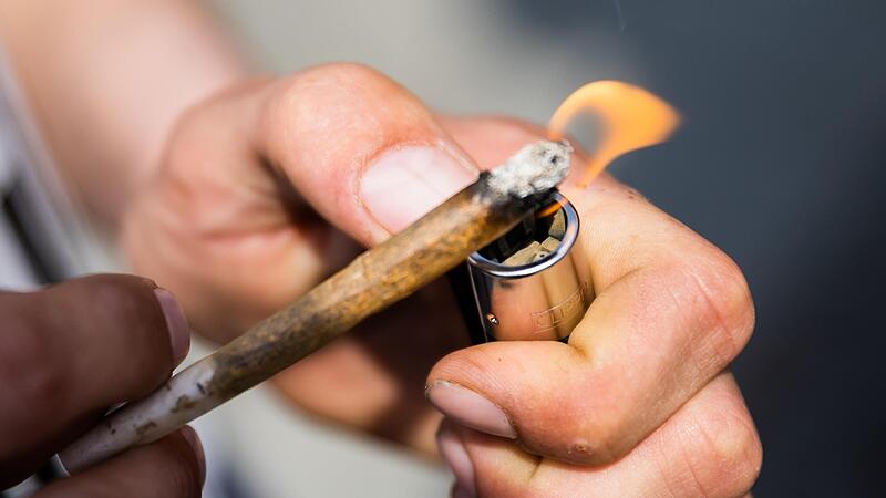 Ein Mann zündet bei der Auftaktkundgebung einer Demonstration für eine zügige Legalisierung von Cannabis, dem «Global Marijuana March 2022», am Brandenburger Tor einen Joint mit Medizinalcannabis an. Ein Mann zündet bei der Auftaktkundgebung einer Demonstration für eine zügige Legalisierung von Cannabis, dem «Global Marijuana March 2022», am Brandenburger Tor einen Joint mit Medizinalcannabis an.