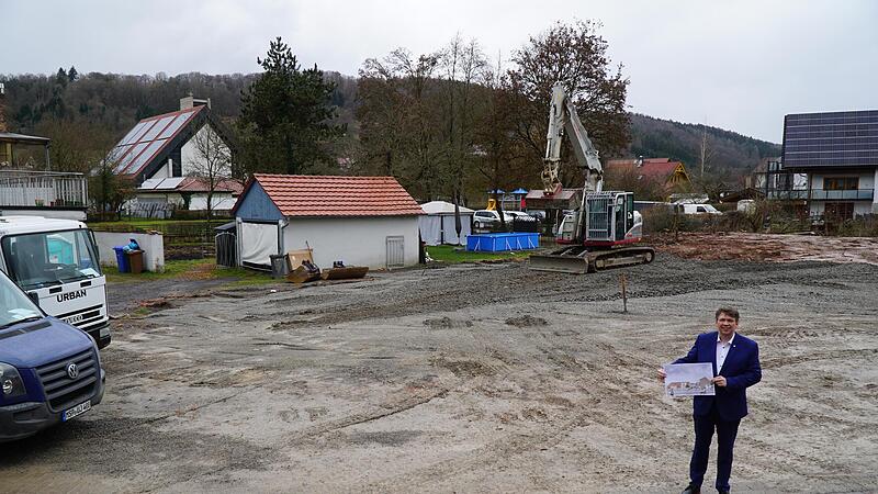 Auf diesem freien Platz zwischen Dorfladen, neuer katholischer Kirche und evangelischer Kirche soll das &Auml;rztehaus mit Dorfladen und Gemeindesaal entstehen. B&uuml;rgermeister Johannes Wagenpfahl zeigt dazu einen ersten Entwurf.