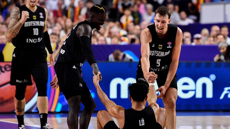 Gemeinsam sind sie stark: Dennis Schröder (links) und Franz Wagner helfen Maodo Lo beim aufstehen.