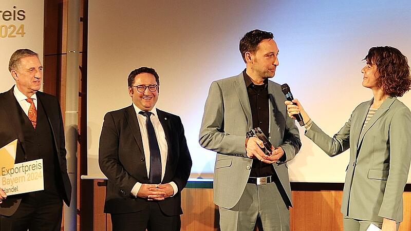 Firmenchef Michael Brux (Zweiter von rechts) nach der Verleihung des Exportpreises Bayern 2024 (Kategorie Handel) an die Firma Bruxsafol mit (von links) Jury-Mitglied Michael Zink (Bayerischer Fliesenhandel GmbH), Staatssekret&auml;r Tobias Gotthardt (Bayerisches Wirtschaftsministerium) und Moderatorin Heike Zeller.