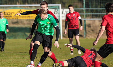 Illia Polishchuk (gr&uuml;nes Trikot) deutete sein Potenzial gegen den FC Baiersdorf bereits an. Hier behauptet er trotz einer Gr&auml;tsche von Sebastian Zydeck den Ball.