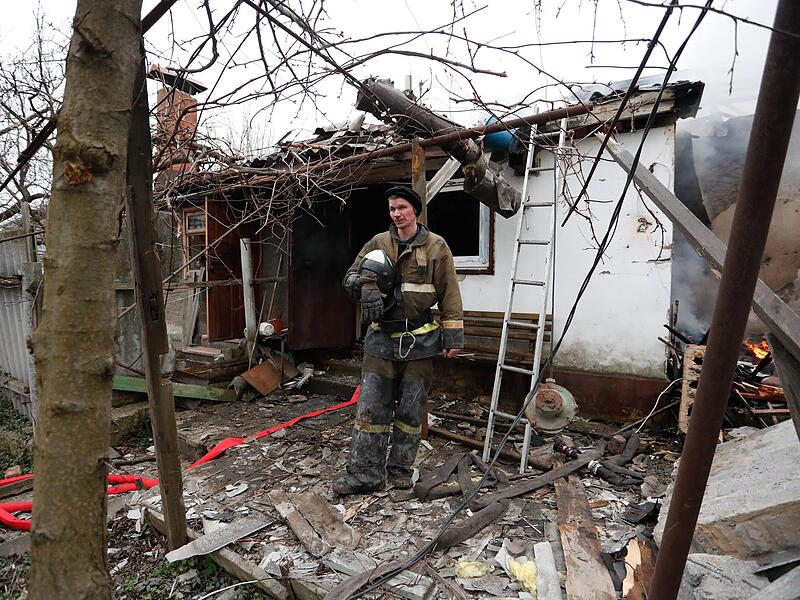 Ein Feuerwehrmann steht am 28.02. neben einem beschädigten Haus in dem von Separatisten besetzen Gebiet in der Ostukraine.