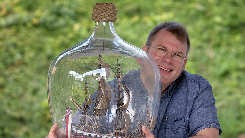 Buddelschiffbauer will neuen Rekord aufstellen Matthias Schultz sitzt neben einem von ihm gebauten 40 Zentimeter hohen und 38 Zentimeter langem Buddelschiff welches in einem 50 Liter fassenden Gärballon hängt. Mit dem «größten freischwebenden Buddelschiff der Welt» will der Modellbauer in das Guinness-Buch der Rekorde kommen.
