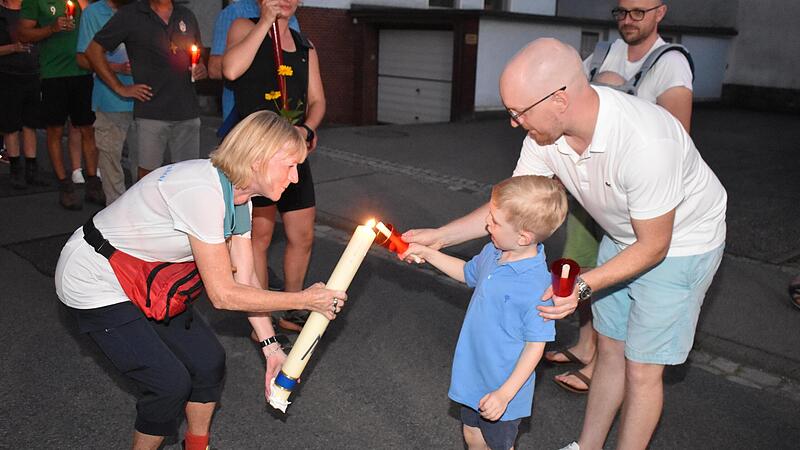 Maximilian entz&uuml;ndet seine Lichterprozessionskerze an der Wallfahrtskerze seiner Oma bei der Abholung in Ramsthal.