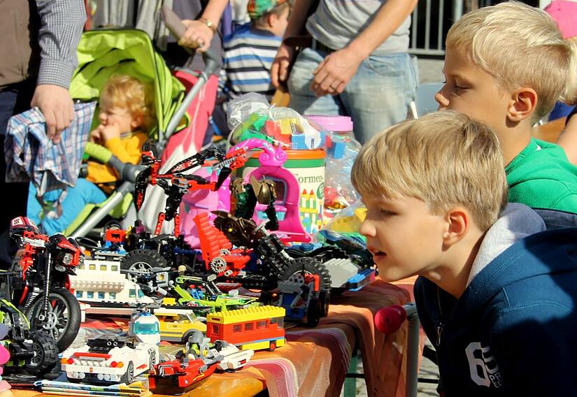 Die Schnäppchen beim Kinderflohmarkt werden genau unter die Lupe genommen, bevor sie den Eigentümer wechseln.