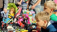 Die Schnäppchen beim Kinderflohmarkt werden genau unter die Lupe genommen, bevor sie den Eigentümer wechseln.