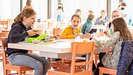 Das gemeinsame Mittagessen findet in der Mensa des Egbert-Gymnasiums M&uuml;nsterschwarzach statt. Dort k&ouml;nnen die Kinder entweder das vor Ort frisch zubereitete Essen mit regionalen Produkten buchen oder ihr eigenes Essen mitbringen.