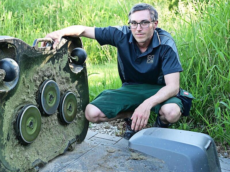 Platzwart Stefan J&ouml;dicke mit einem der M&auml;hroboter.