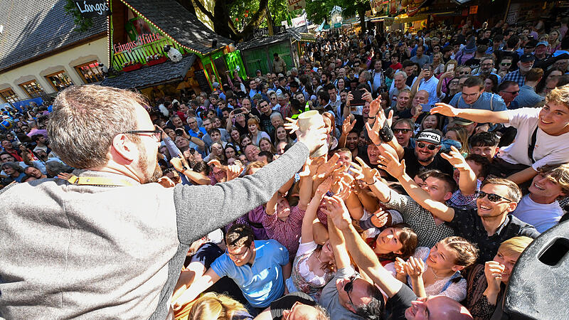 Oberbürgermeister Florian Janik reicht das erste Bier in die Menge.