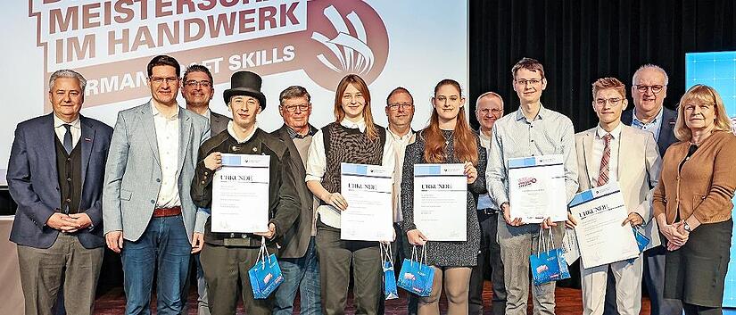 Eingerahmt von HWK-Verantwortlichen und Ehreng&auml;sten posierten die Kammersieger aus Stadt und Landkreis Coburg f&uuml;rs Foto (mit Urkunden, von links): Tom Schreiber, Lisa B&uuml;ttner, Lydia Weiland, Johannes Imhof und Jakob Vukadinovic.