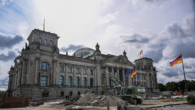 Vor dem Reichstagsgeb&auml;ude in Berlin stehen ein Bagger und Baustellenschilder. Doch auch im Geb&auml;ude muss die Ampel-Koalition  um diverse Baustellen k&uuml;mmern.