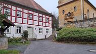 Der Kirchenvorplatz (links das Gemeindehaus) in Kunreuth soll saniert werden. Denn 2026 steht eine große Feier bevor.Forchheim & Fränkische Schweiz