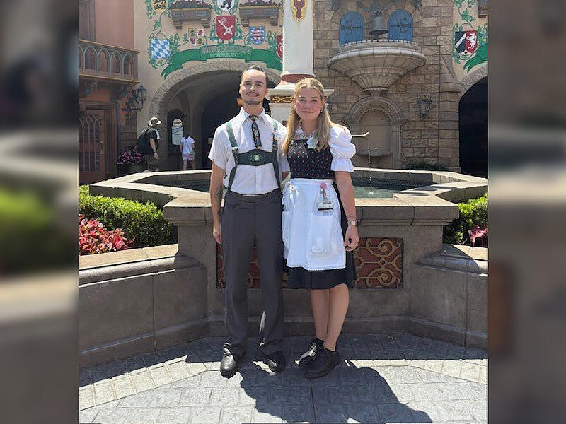 Emma Pietsch und ein Freund in ihren Kost&uuml;men in der Mitte des Germany Pavilions in EPCOT