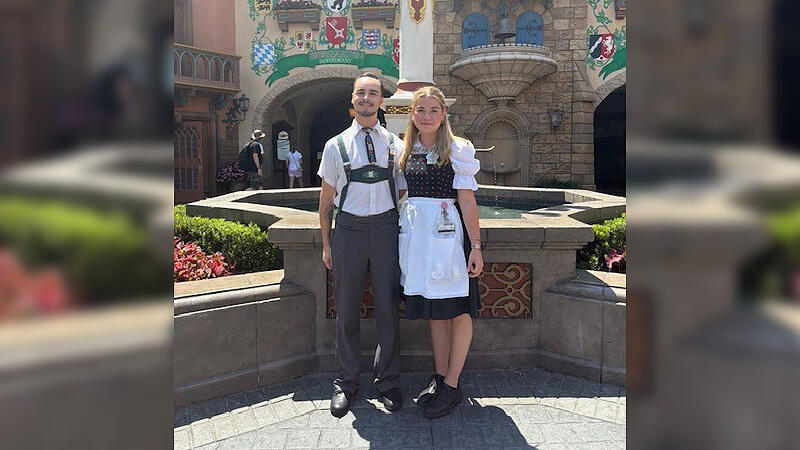Emma Pietsch und ein Freund in ihren Kost&uuml;men in der Mitte des Germany Pavilions in EPCOT