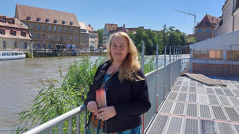 Katharina Stubenrauch hilft seit Kindesbeinen ehrenamtlich bei der Sandkerwa mit. Zu ihrer Rechten wird gerade das Festzelt aufgebaut.