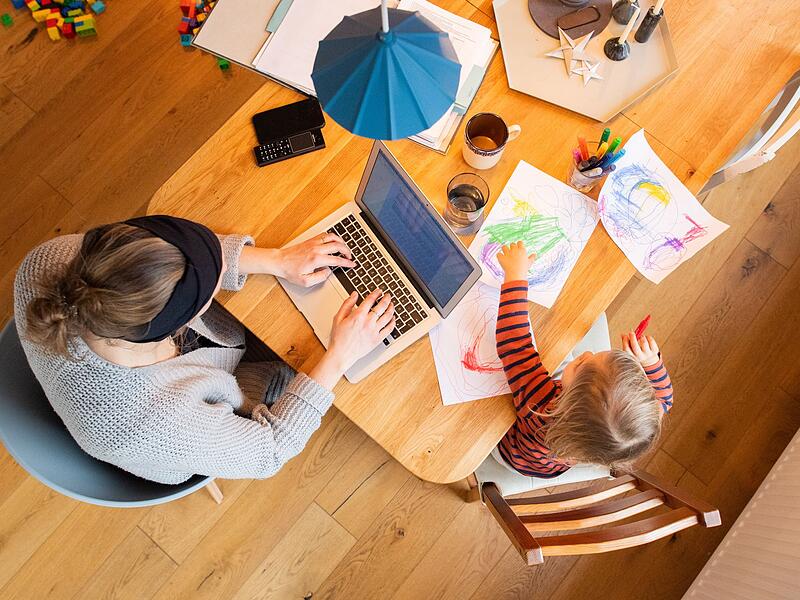 Eine Frau arbeitet im Homeoffice mit Kind