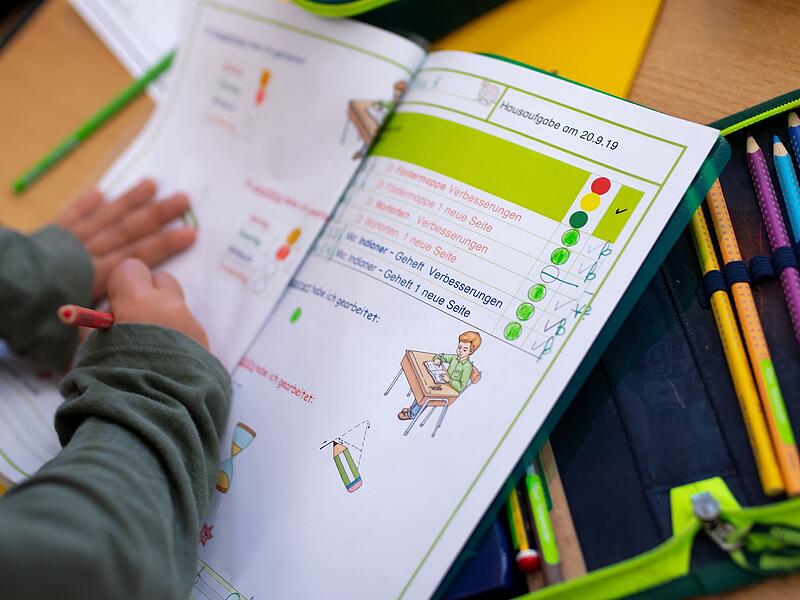 Kind arbeitet in Schulheft