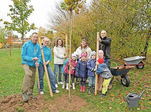 Die LG-Akteure zusammen mit einigen Kita- Kindern nach dem Einpflanzen des 2,20 Meter großen Kugelahornbaumes im Garten der Kita St. Elisabeth in Ludwigschorgast.