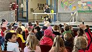 Timo Wendel liest in der Aula der Grundschule Weisendorf den Schülern vor.
