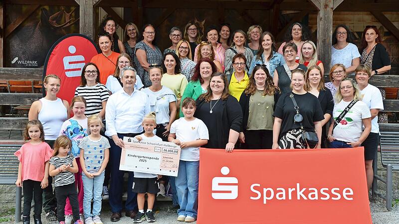 Gruppenbild mit Sparkassen-Logo: (v.l.) Waldpädagogin Sarah Keller, der Vorstandsvorsitzende der Sparkasse Schweinfurt-Haßberge, Peter Schleich, und die Erzieherinnen und Erzieher der geförderten Kindergärten.