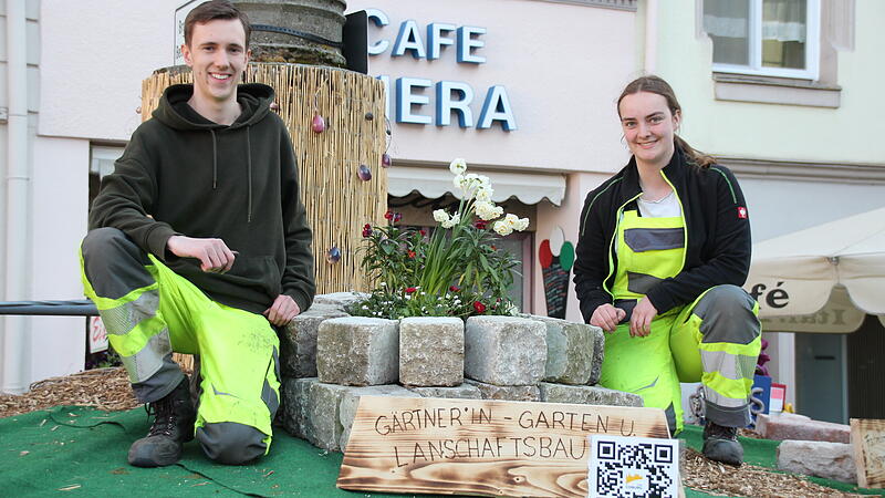 Tobias Hahn und Laura Zahner schmücken noch eifrig den Spenglersbrunnen. Die Schilder mit Ausbildungsberufen und QR-Codes erhalten auch noch den letzten Feinschliff.