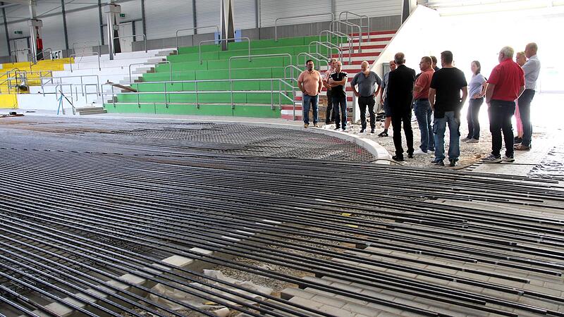 Der Bauausschuss des Stadtrats und einige G&auml;ste informierten sich an dem 24 Kilometer langen Rohrgeflecht &uuml;ber den Fortgang der Bauarbeiten im H&ouml;chstadter Eisstadion.