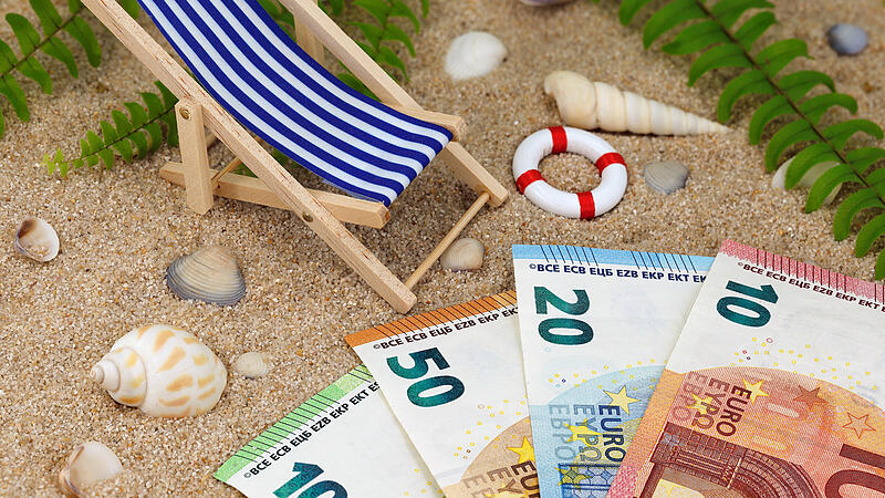 deck chair with euro banknotes in the sand with sea shells and tropical background, concept of saving money for a holiday trip or high vacation expensesForchheim & Fr&auml;nkische Schweiz