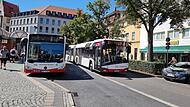 Ein Bus der Stadtwerke (l.) neben einem einfahrenden gecharterten Bus.