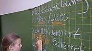 Eine Sch&uuml;lerin schreibt an der Schultafel.