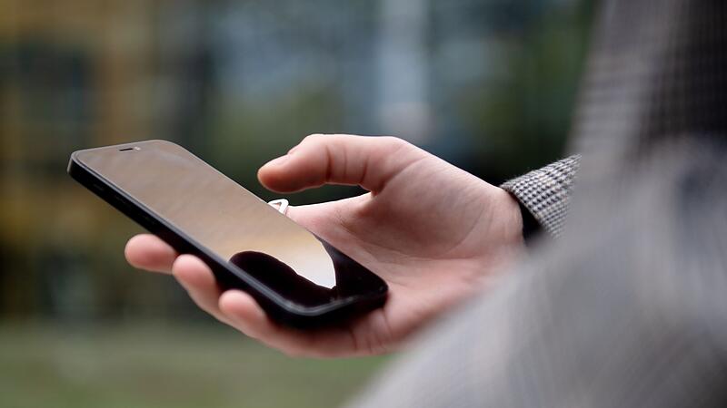 Eine Person hat ein Smartphone in der Hand Eine Person hat ein Smartphone in der Hand