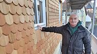 Rudolf Pastovic auf dem Ger&uuml;st am historischen Teil des Hauses, das er gerade aufwendig sanieren l&auml;sst. Selbst f&uuml;r die Holzschindeln der Fassade gelten Vorgaben zum Ensembleschutz.