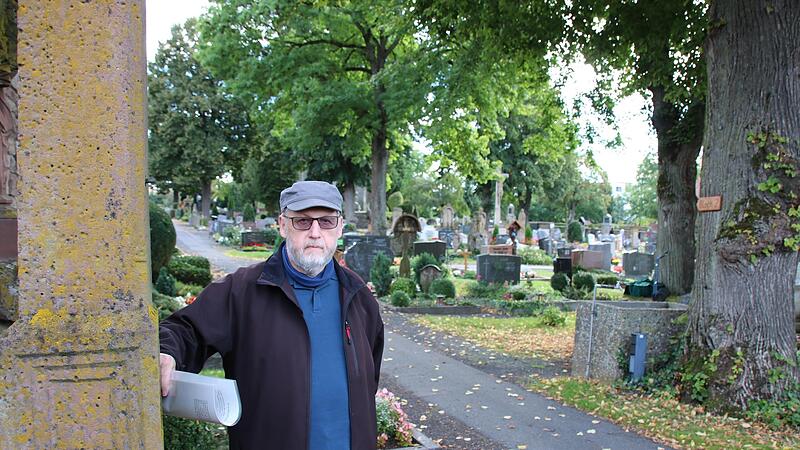 Franz Josef Schneider zeigt die älteste erhaltene Grabstelle auf dem Hammelburger Friedhof: In der südwestlichen Ecke steht ein Sandsteinkreuz aus dem Jahr 1548. Franz Josef Schneider zeigt die älteste erhaltene Grabstelle auf dem Hammelburger Friedhof: In der südwestlichen Ecke steht ein Sandsteinkreuz aus dem Jahr 1548.
