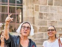 Bei der Kostümführung erklärt eine Stadtführerin als Hugenottin Wissenswertes über die Geschichte von Erlangen.