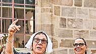 Bei der Kostümführung erklärt eine Stadtführerin als Hugenottin Wissenswertes über die Geschichte von Erlangen.