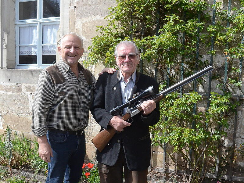 Das im 94.Lebensjahr stehende Ehrenmitglied Adolf Beier (rechts) sorgte mit seinem Schuss ins Schwarze f&uuml;r Furore und Freude unter den J&auml;gern.  Vorsitzender Bernhard Schmitt gratulierte und meinte, eigentlich sei das mehr als nur ein Schulterklopfen wert. Adolf Beier ist seit 75 Jahren zuverl&auml;ssiger Waidmann im Gutswald, der von Cramer-Klett im Raum Mitwitz, seit einigen Jahren forstwirtschaftliche G&uuml;terverwaltung Reinau.