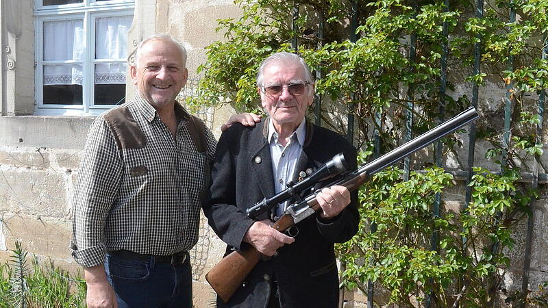 Das im 94.Lebensjahr stehende Ehrenmitglied Adolf Beier (rechts) sorgte mit seinem Schuss ins Schwarze f&uuml;r Furore und Freude unter den J&auml;gern.  Vorsitzender Bernhard Schmitt gratulierte und meinte, eigentlich sei das mehr als nur ein Schulterklopfen wert. Adolf Beier ist seit 75 Jahren zuverl&auml;ssiger Waidmann im Gutswald, der von Cramer-Klett im Raum Mitwitz, seit einigen Jahren forstwirtschaftliche G&uuml;terverwaltung Reinau.