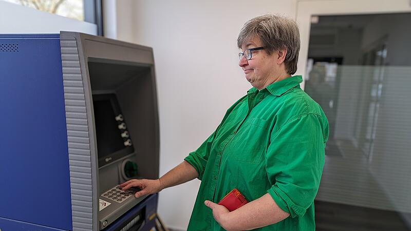 Karin Steinbach versucht am Automaten der Postbank Bargeld abzuheben.