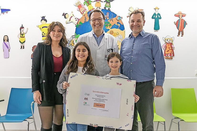 Stellvertretend f&uuml;r alle Kinder der F&uuml;rther &bdquo;Villa Kunterbunt&ldquo; &uuml;berreichten die beiden Viertkl&auml;sslerinnen Mina (l.) und Emma den symbolischen Spendenscheck an Professor Markus Metzler (Kinderonkologie Uniklinikum Erlangen). Soultana Papadopulos (L...
