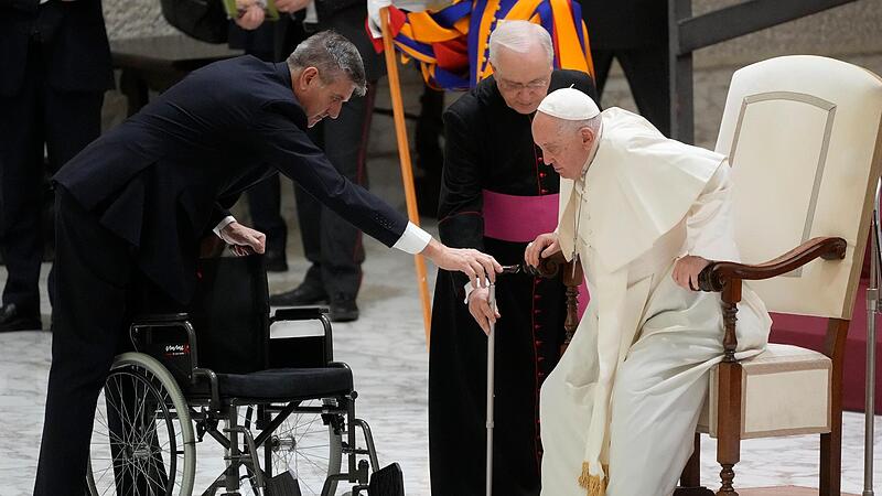 Papst Franziskus steht während der Generalaudienz im Vatikan auf, um zu seinem Rollstuhl zu gehen.