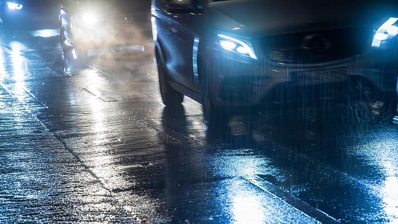 Autos fahren bei gefrierenden Regen &uuml;ber eine Stra&szlig;e
