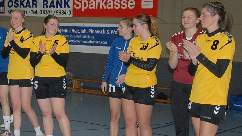 Spielerinnen der HSG Volkach beklatschen ihren Sieg in der Handball-Bezirksoberliga im Spitzenspiel gegen die HSG Mainfranken. Die Volkacherinnen führen die Tabelle weiterhin verlustpunktfrei an.