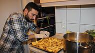 Mohammed Abukadib bereitet Rosmarinkartoffeln für das Buffet zu.