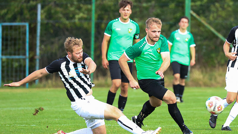 Mit einer Grätsche trennt der Burgkunstadter Jan-Hendrik Straten (schwarz-weiß) Steve Schön vom Ball. Mit einer Grätsche trennt der Burgkunstadter Jan-Hendrik Straten (schwarz-weiß) Steve Schön vom Ball.
